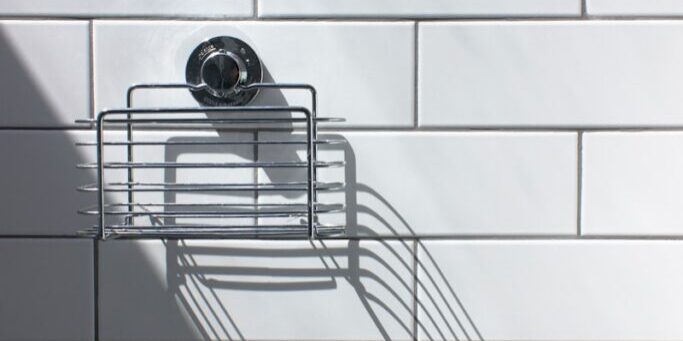 black and silver round analog watch on white ceramic wall tiles