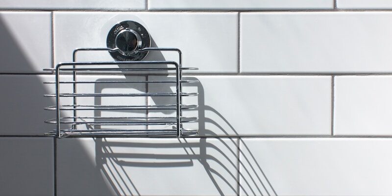 black and silver round analog watch on white ceramic wall tiles